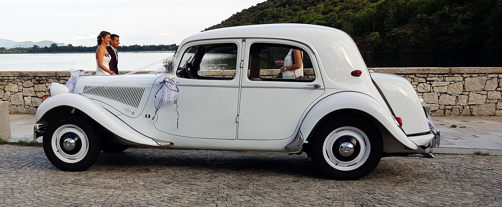 Il profilo della Traction Avant sul lungolago, con gli sposi accanto